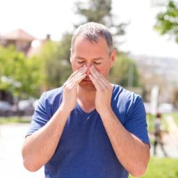 Man holding his nose in pain