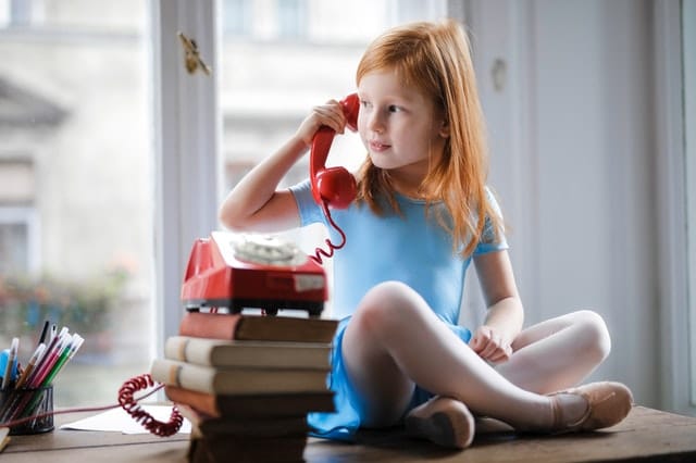 Young girl sitting on a table talking on the phone