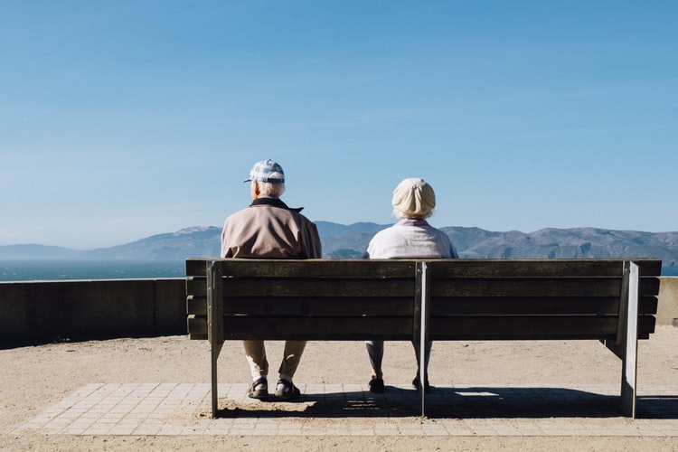 Older couple sitting on a bench together.