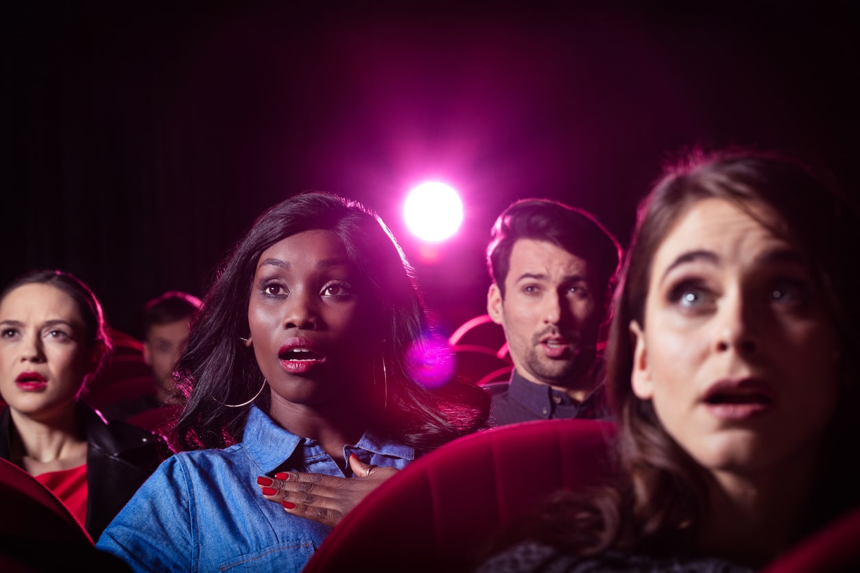 People watch an action movie in theater