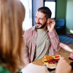 Man with hearing aids interacts at dinner