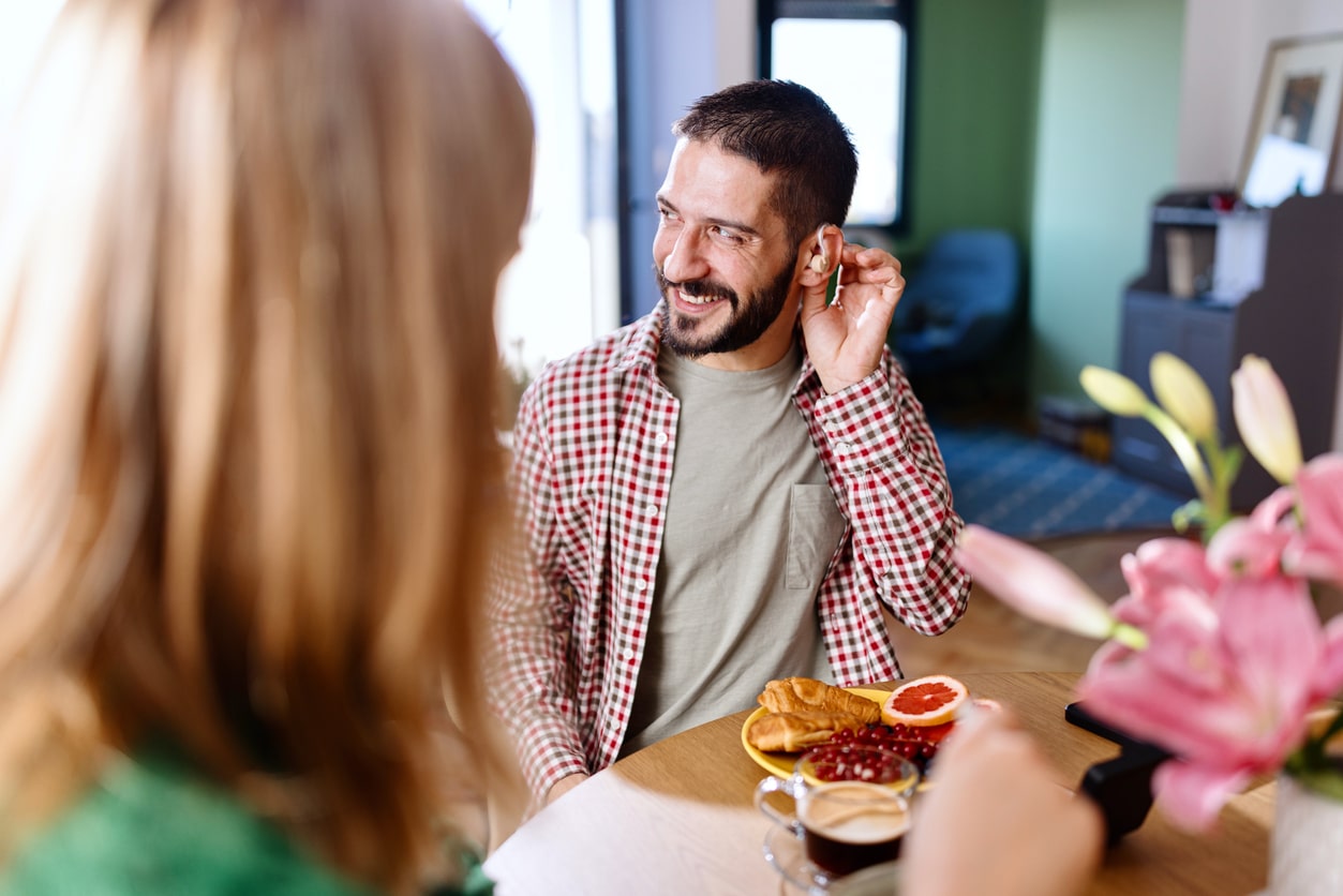 Man with hearing aids interacts at dinner