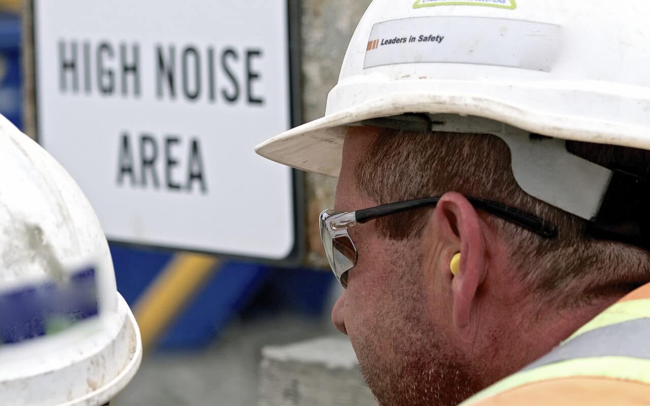 Man on construction site with earplugs