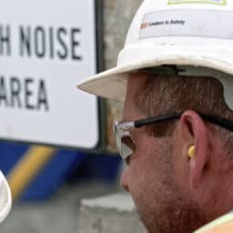 Man on construction site with earplugs